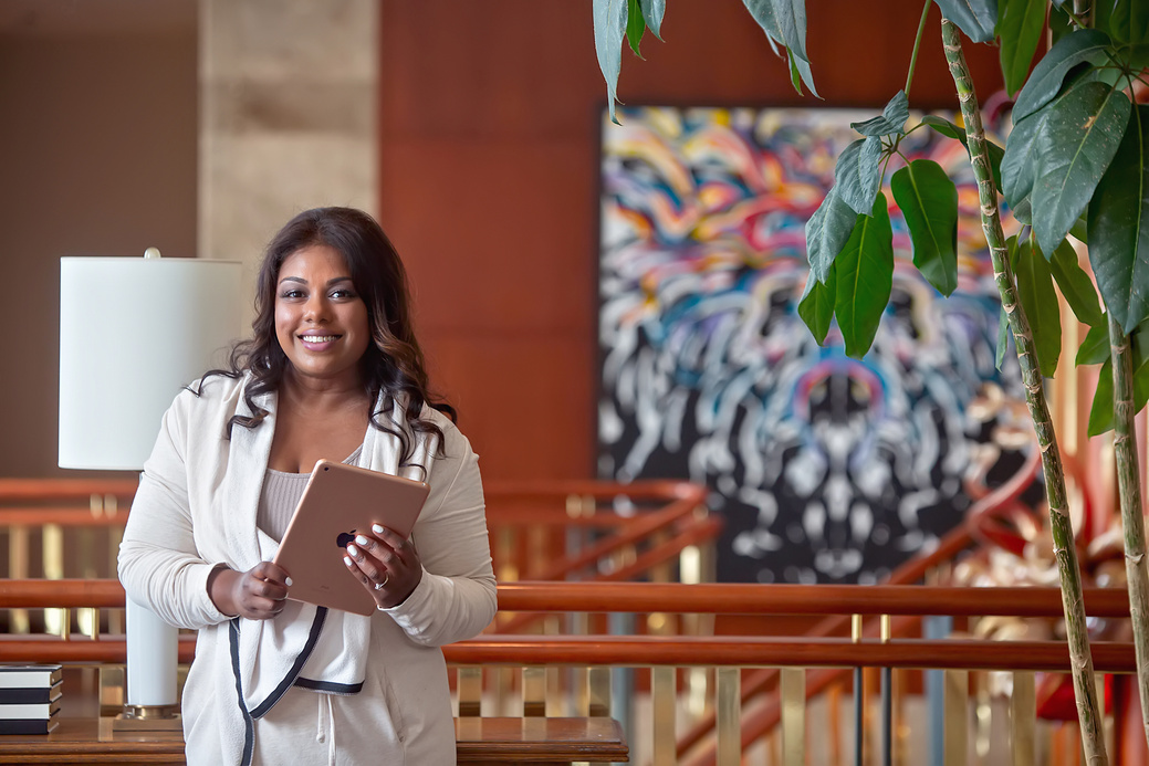 une personne souriante tenant un iPad