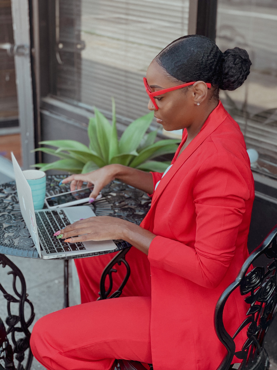 a person in a red suit sitting at a table with a laptop